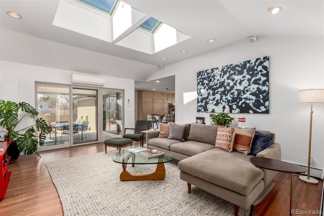 living area featuring lofted ceiling with skylight, recessed lighting, light wood-style floors, and a wall mounted AC