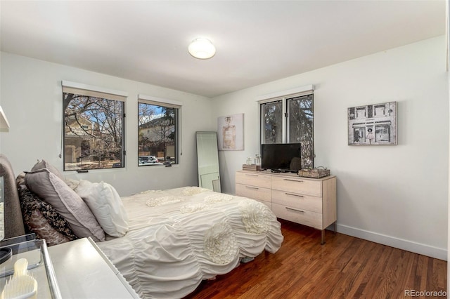 bedroom with dark wood-type flooring and baseboards