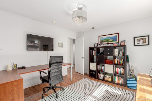 office area with a chandelier, visible vents, and wood finished floors