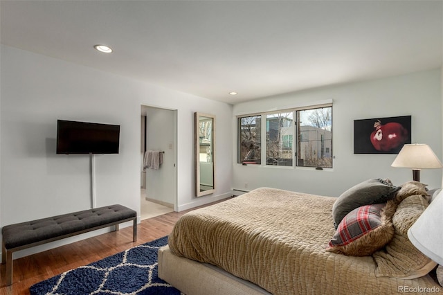 bedroom with baseboards, a baseboard radiator, wood finished floors, and recessed lighting