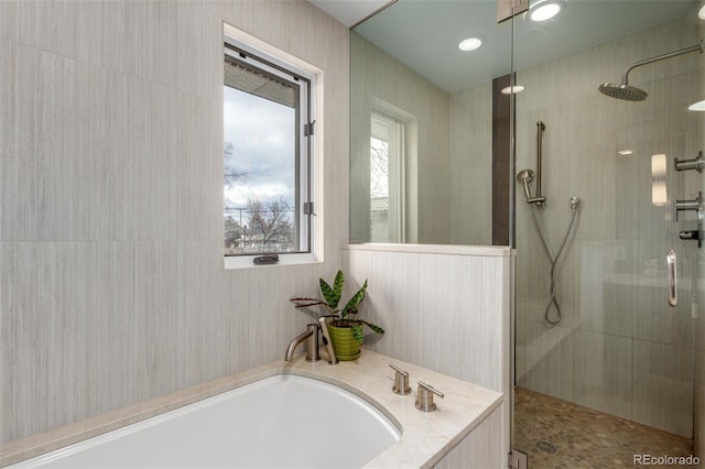 full bathroom featuring a tile shower and a bath