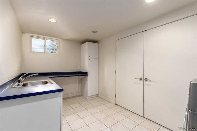 kitchen with light tile patterned floors, white cabinetry, a sink, and recessed lighting