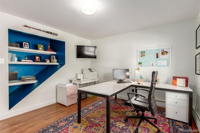 office featuring baseboards, baseboard heating, and wood finished floors