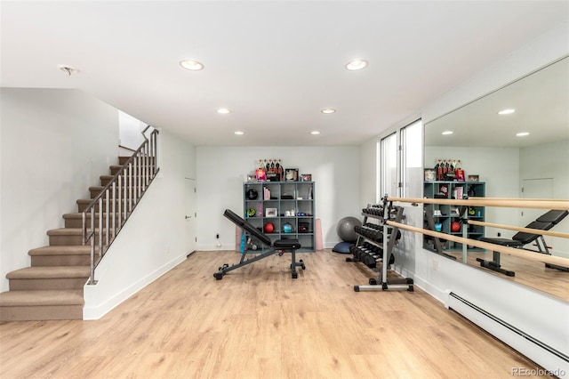 exercise room featuring baseboards, baseboard heating, wood finished floors, and recessed lighting