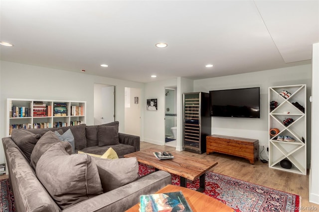 living area featuring baseboards, wood finished floors, and recessed lighting