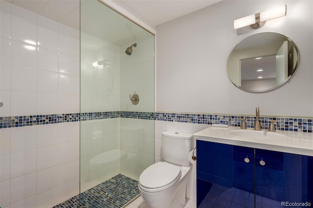 full bath with toilet, tile walls, tiled shower, and vanity