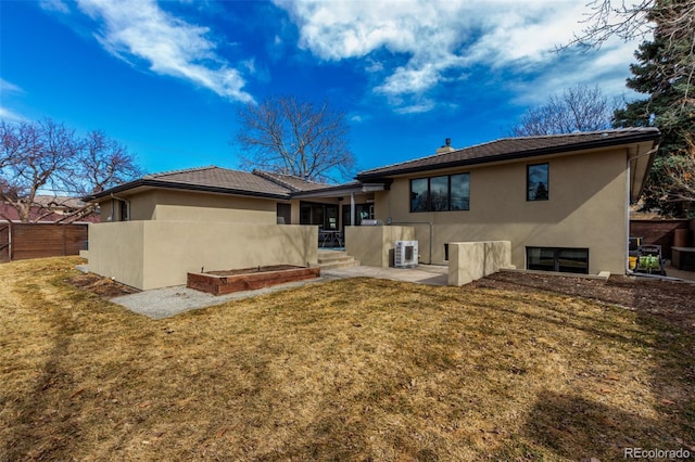 rear view of house with a patio, fence, a yard, central air condition unit, and stucco siding