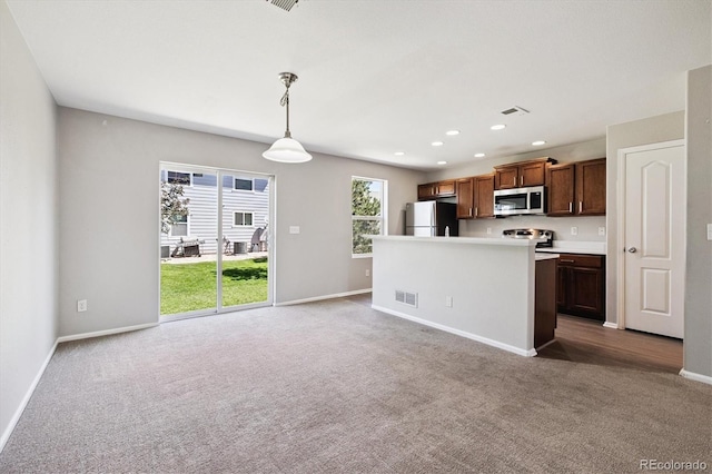 19209 E 58th Ave Unit C, Denver, CO 80249 - kitchen featuring stainless steel microwave, freestanding refrigerator, carpet floors, decorative light fixtures, and recessed lighting