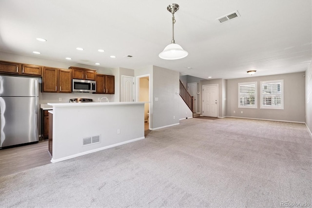19209 E 58th Ave Unit C, Denver, CO 80249 - kitchen featuring stainless steel appliances, light carpet, brown cabinets, recessed lighting, and light countertops