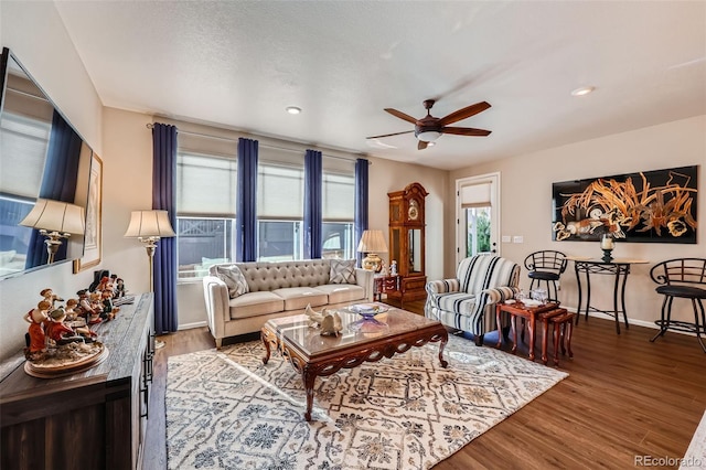 living room featuring hardwood / wood-style floors and ceiling fan