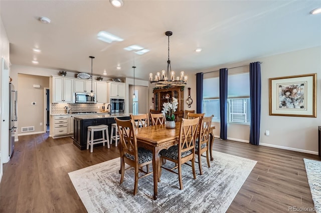 dining space featuring dark hardwood / wood-style flooring and a notable chandelier