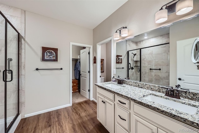 bathroom featuring hardwood / wood-style floors, vanity, and a shower with shower door