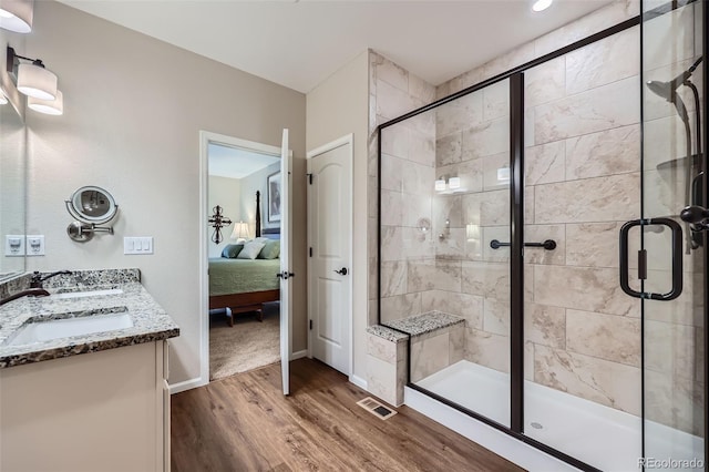 bathroom featuring hardwood / wood-style floors, walk in shower, and sink