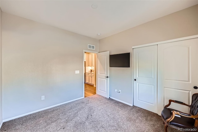 unfurnished bedroom with light carpet and a closet