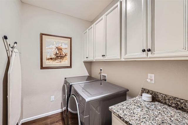 laundry room with cabinets, independent washer and dryer, and dark hardwood / wood-style floors