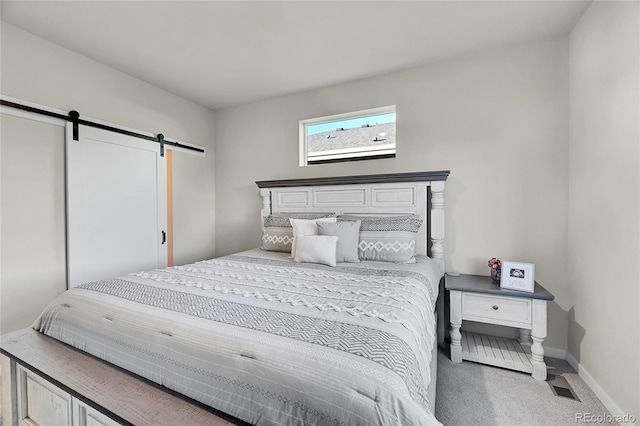 carpeted bedroom featuring a barn door