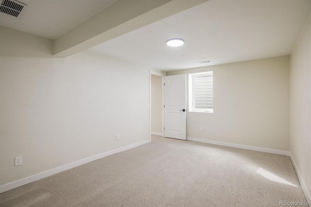 empty room with baseboards, visible vents, and light carpet
