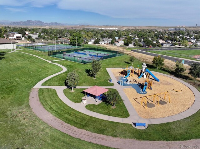 view of property's community with a lawn, a mountain view, and playground community
