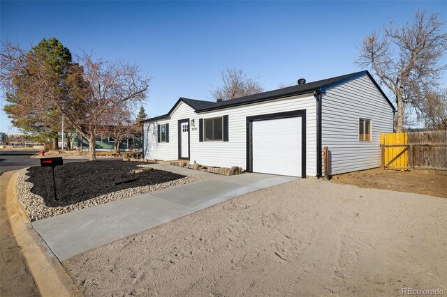 single story home with fence, driveway, and a garage