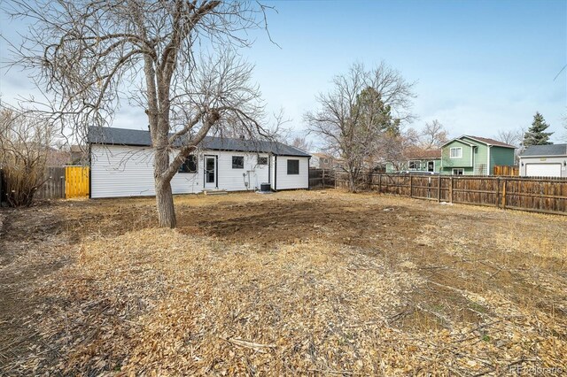 rear view of house with a fenced backyard