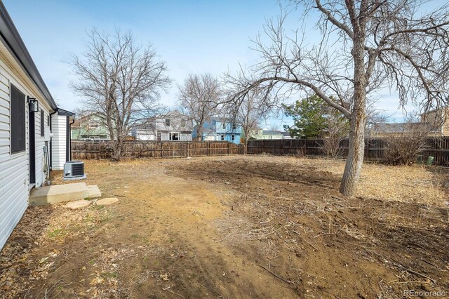 view of yard with central air condition unit and a fenced backyard