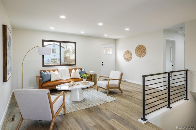 sitting room featuring baseboards, recessed lighting, and light wood-style floors