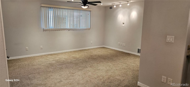 carpeted spare room featuring baseboards, visible vents, and a ceiling fan