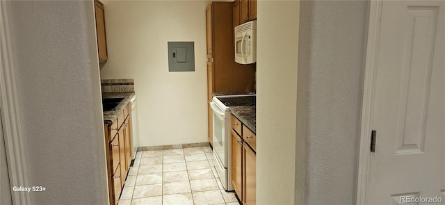 kitchen featuring white appliances, light tile patterned floors, electric panel, baseboards, and brown cabinetry