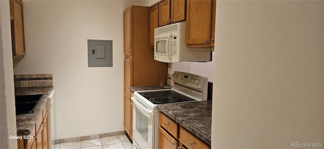 kitchen with white appliances, baseboards, electric panel, brown cabinets, and dark stone countertops