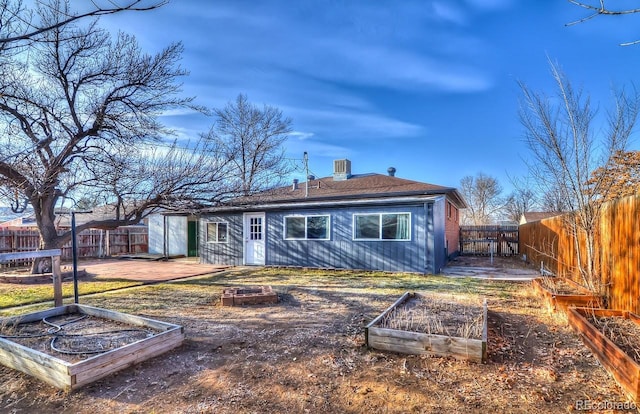 back of house with central AC unit and a storage shed