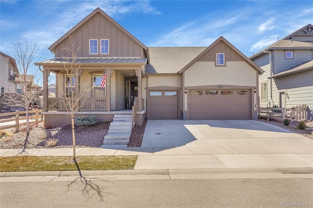 view of front of home featuring a porch, board and batten siding, concrete driveway, and fence