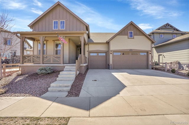 view of front of property with concrete driveway, fence, covered porch, and board and batten siding