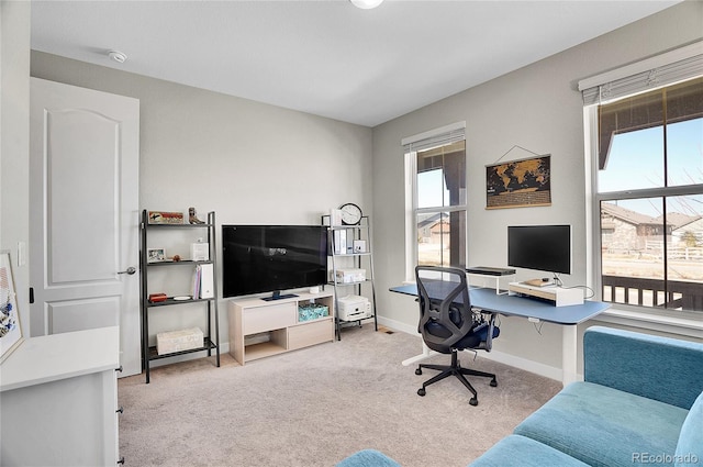 home office featuring baseboards, carpet floors, and a healthy amount of sunlight