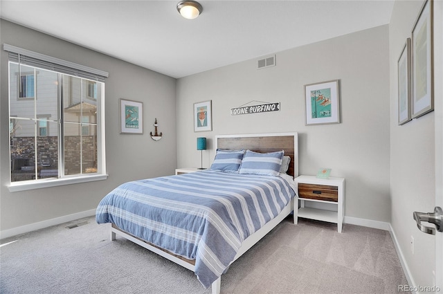 carpeted bedroom featuring visible vents, baseboards, and multiple windows