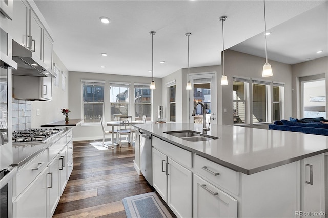 kitchen with recessed lighting, dark wood-style flooring, a sink, appliances with stainless steel finishes, and backsplash