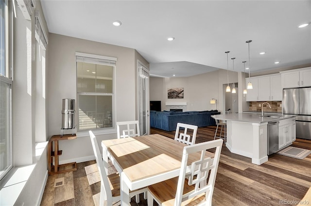 dining room with visible vents, baseboards, dark wood finished floors, recessed lighting, and a fireplace