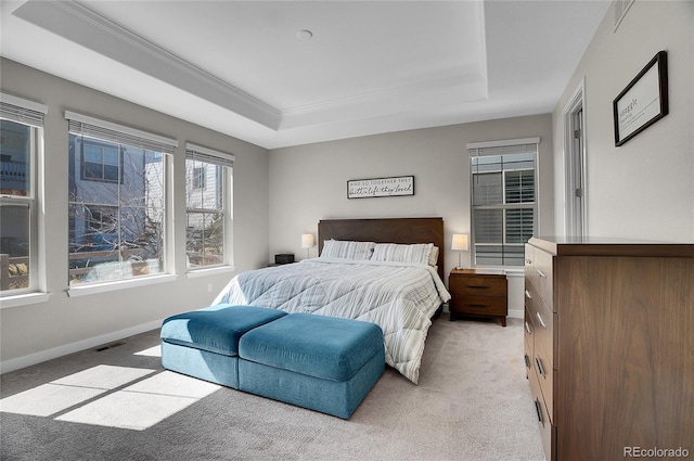 bedroom with a tray ceiling, visible vents, baseboards, and light carpet