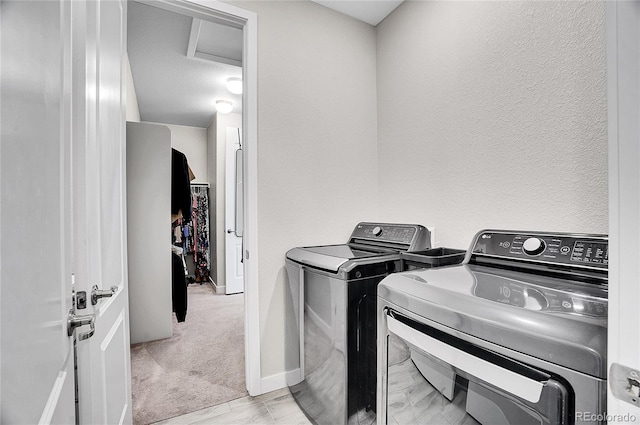 washroom featuring laundry area, independent washer and dryer, baseboards, and a textured wall