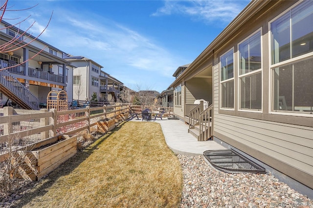 view of yard featuring a patio, a fenced backyard, and a residential view