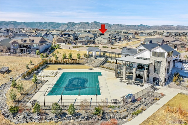 community pool featuring a mountain view, a residential view, a patio, and fence