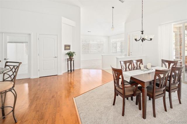 dining area with a notable chandelier and light hardwood / wood-style flooring