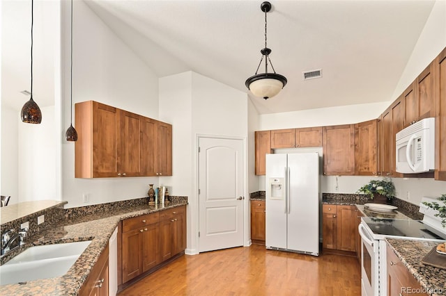 kitchen featuring white appliances, light hardwood / wood-style flooring, pendant lighting, high vaulted ceiling, and sink