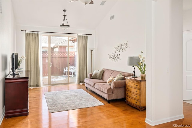 living area featuring ceiling fan, hardwood / wood-style floors, and vaulted ceiling