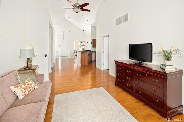 living room with high vaulted ceiling, light wood-type flooring, and ceiling fan