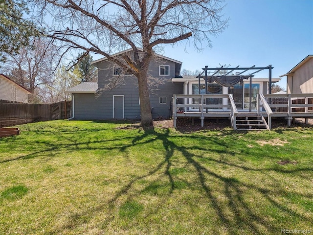 5945 W Morraine Ave, Littleton, CO 80128 - rear view of house featuring a wooden deck, fence, and a lawn