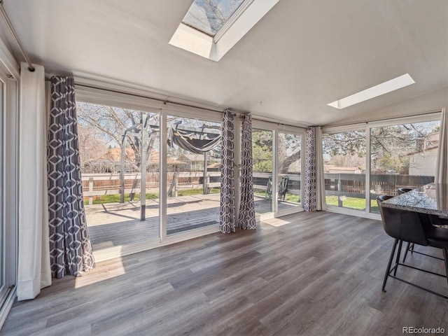 5945 W Morraine Ave, Littleton, CO 80128 - unfurnished sunroom with a healthy amount of sunlight, a deck, lofted ceiling with skylight, and wood finished floors