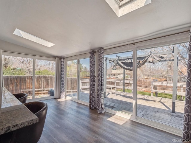 5945 W Morraine Ave, Littleton, CO 80128 - sunroom featuring vaulted ceiling with skylight, wood finished floors, and a deck