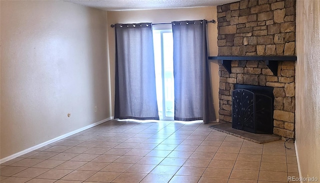 unfurnished living room featuring a fireplace, tile patterned floors, and a textured ceiling