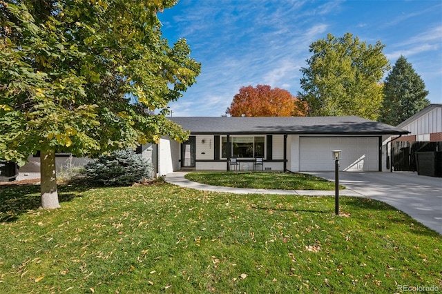 view of front of property with a garage, a front lawn, and concrete driveway