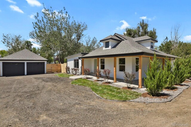 view of front of house featuring a garage, an outdoor structure, and covered porch